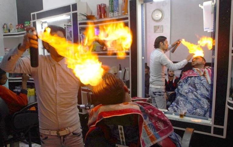 Парикмахер укладывает клиентов огнем